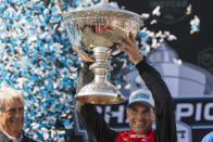 Team Penske driver Will Power, of Australia, holds up the championship trophy after winning the championship after the IndyCar season finale auto race at Laguna Seca Raceway on Sunday, Sept. 11, 2022, Monterey, Calif. (AP Photo/Nic Coury)
