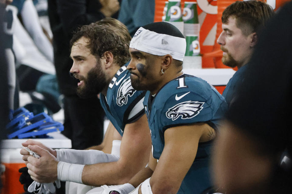 Philadelphia Eagles quarterback Jalen Hurts (1) sits with tight end Dallas Goedert, left, on the bench during the first half of an NFL football game against the Dallas Cowboys, Sunday, Dec. 10, 2023, in Arlington, Texas. (AP Photo/Michael Ainsworth)