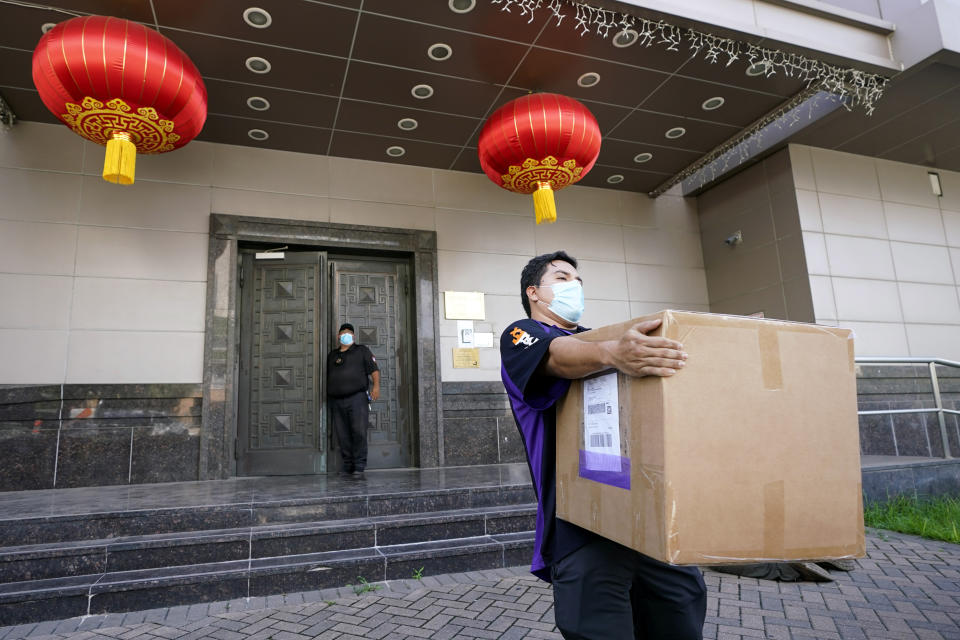 A FedEx employee removes a box from the Chinese Consulate Thursday, July 23, 2020, in Houston. China says “malicious slander" is behind an order by the U.S. government to close its consulate in Houston, and maintains that its officials have never operated outside ordinary diplomatic norms. (AP Photo/David J. Phillip)