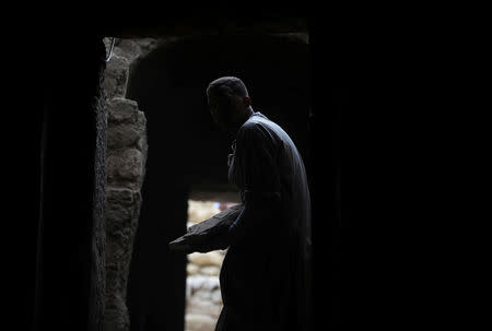 A worker carries an artefact inside the tomb of Khufu-Imhat, at the Saqqara area near its necropolis, in Giza, Egypt November 10, 2018. REUTERS/Mohamed Abd El Ghany