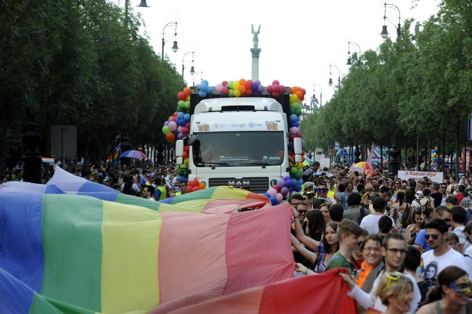 FILE - In this Saturday, July 6 2013 file photo participants walk down Andrassy Street under a giant rainbow flag during the 18th Budapest Gay Pride March in Budapest, Hungary. Fidesz, the ruling party of Prime Minister Viktor Orban, tabled amendments in Parliament on Thursday, June 12 to new legislation that bans showing to people under 18 pornographic materials or any content encouraging gender change or homosexuality. The party describes the new legislation as part of an effort to protect children from pedophilia. But LGBT rights activists denounced the bills as discriminatory, with some comparing it to a 2013 Russian law banning so-called gay “propaganda.”(AP Photo/MTI, Imre Foldi, file)