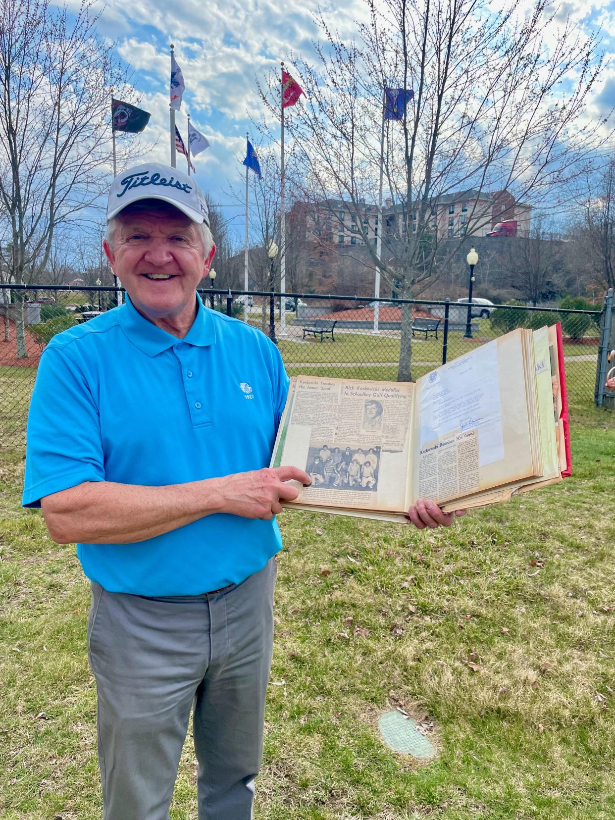 At Auburn Driving Range, Rick Karbowski points to photo of his 1973 Auburn High School state championship golf team in scrapbook his mother kept.