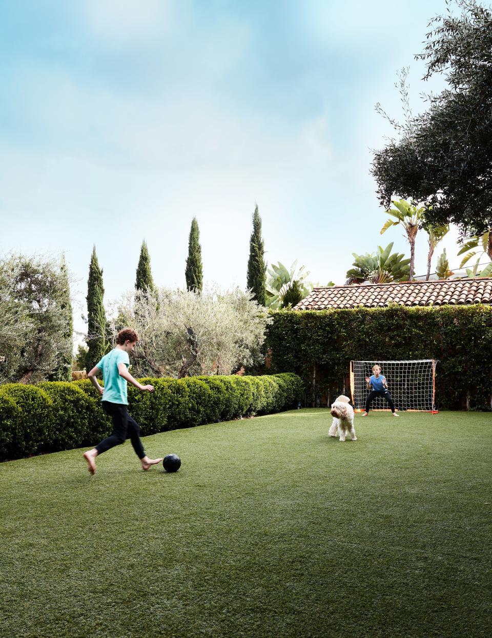 Miles (left) and Henry play soccer in the garden.