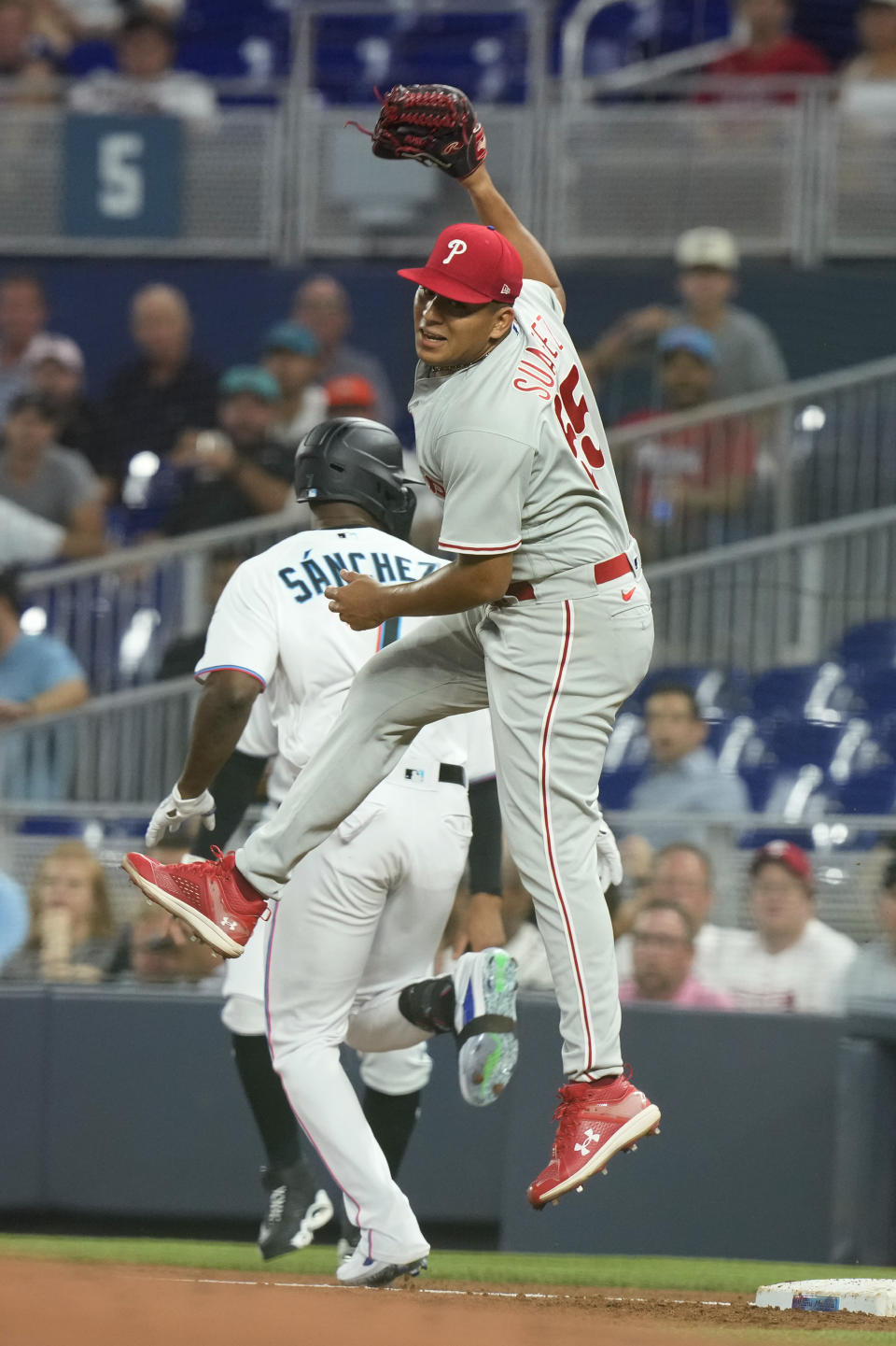 Miami Marlins' Jesus Sanchez (7) beats the tag on first base by Philadelphia Phillies starting pitcher Ranger Suarez (55) during the first inning of a baseball game, Tuesday, Aug. 1, 2023, in Miami. (AP Photo/Marta Lavandier)