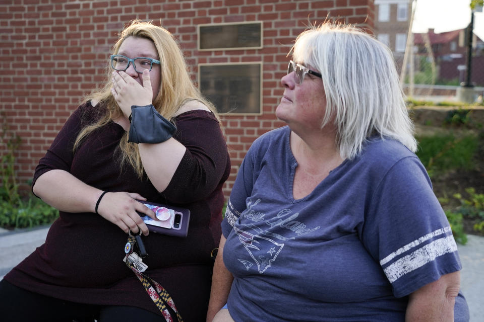 Haley Marcussen, left, reacts while sitting next to her mother Elyzabeth Marcussen, a former community editor at the Annapolis Capital Gazette newspaper, at the Guardians of the First Amendment memorial, which is dedicated to the victims of the newsroom shooting of 2018, Thursday, July 15, 2021, in Annapolis, Md. Elyzabeth Marcussen left the paper three years prior to the shooting, but still had friendships with staff, including most of the people killed by Jarrod W. Ramos, the gunman which jury found criminally responsible, rejecting defense attorneys' mental illness arguments, on Thursday. (AP Photo/Julio Cortez)