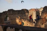 En esta imagen, tomada el 5 de abril de 2017, niños juegan en el interior de las ruinas de San Francisco, en el vecindario de San Antón, en la zona colonial de Santo Domingo, República Dominicana. Pese a su riqueza histórica, la ciudad vivió décadas de abandono, sobre todo después de la guerra civil de 1965, cuando muchos de sus residentes se mudaron a los modernos centros residenciales de la capital. (AP Foto/Tatiana Fernández)