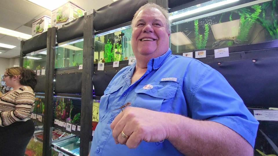 Daryl Waldrop, who is the co-owner of Fins on Fifth with his wife, Lisa, holds one of the 15 baby chameleons recently born there.