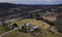 The Tioughnioga River runs by the Itaska Valley Farm, foreground, owned by Harold and Joan Koster, Wednesday, March 13, 2024, in Whitney Point, N.Y. The Kosters were asked by Texas-based Southern Tier Energy Solutions to lease their land to extract natural gas by injecting carbon dioxide into the ground, which they rejected and are opposed to. (AP Photo/Heather Ainsworth)