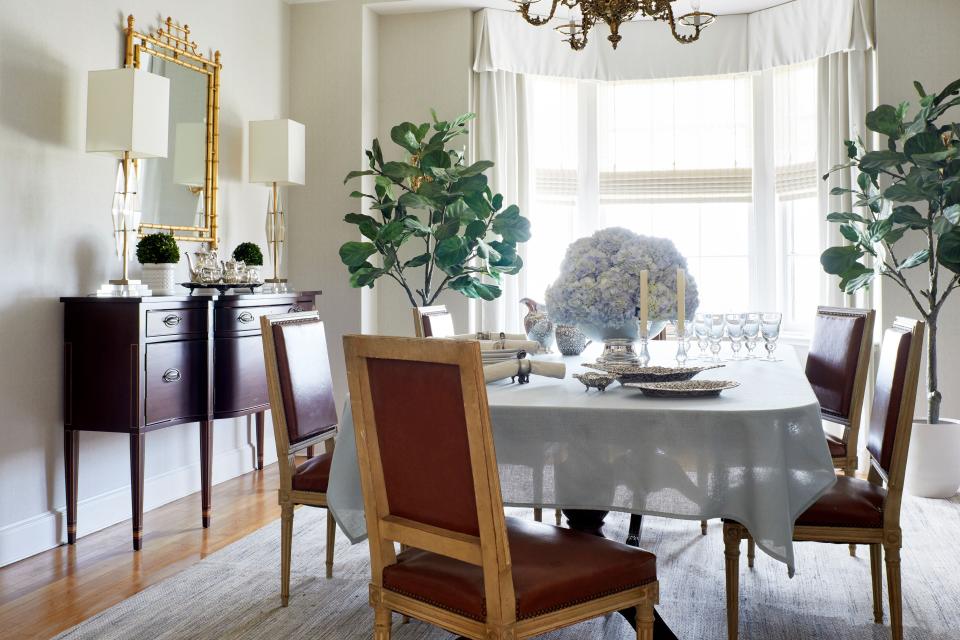 “Since small spaces tend to already radiate a cozy charm, you can embrace this inviting aesthetic by incorporating textures that continue to add layers and warmth,” says interior designer Sara Hillery. “However, if you are trying to make a small dining room appear larger than it is, I recommend keeping its color palette monochromatic—or at least very simple.” A bursting footed silver bowl of hydrangea makes a forever charming centerpiece in this elegant dining room design, while the pair of table lamps supply soft light to the sideboard.