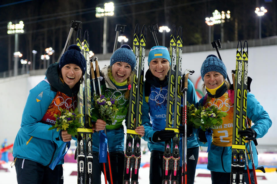 SOCHI, RUSSIA - FEBRUARY 21:  Gold medalists Vita Semerenko, Juliya Dzhyma, Olena Pidhrushna and Valj Semerenko of Ukraine celebrate during the flower ceremony for the Biathlon Women's 4 x 6 km Relay during day 14 of the Sochi 2014 Winter Olympics at Laura Cross-country Ski & Biathlon Center on February 21, 2014 in Sochi, Russia.  (Photo by Harry How/Getty Images)