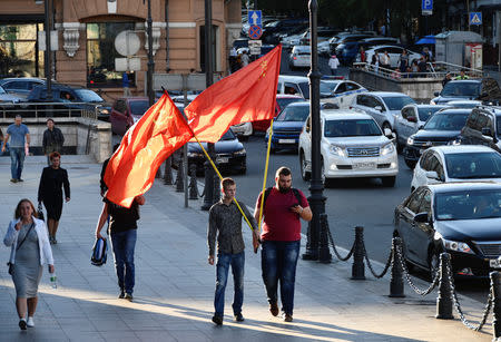 Supporters of candidate Andrei Ischenko hold Soviet flags while walking along a street following the election for governor of Russia's Primorsky Region in the far eastern city of Vladivostok, Russia September 17, 2018. REUTERS/Yuri Maltsev