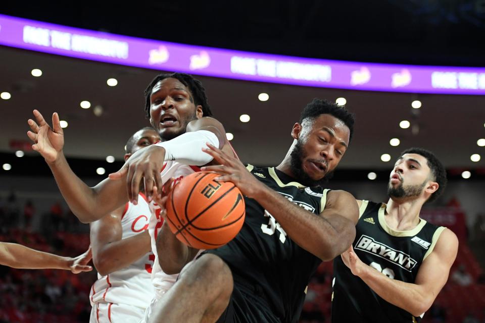 Bryant forward Hall Elisias, second from right, fights for a rebound with Houston center Josh Carlton during the first half of Friday's game.