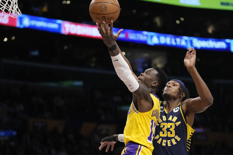 Los Angeles Lakers guard Dennis Schroder, left, shoots as Indiana Pacers center Myles Turner defends during the first half of an NBA basketball game on Monday, November 28, 2022 in Los Angeles.  (AP Photo/Mark J. Terrill)