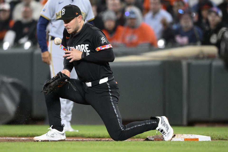 The ball gets away from Baltimore Orioles first baseman Ryan O'Hearn, allowing Milwaukee Brewers' Gary Sánchez to reach first on a throwing error by Orioles' Gunnar Henderson during the fifth inning of a baseball game Friday, April 12, 2024, in Baltimore. Sánchez advanced to second on the play. AP Photo/Nick Wass)