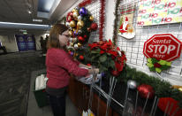 Volunteer Nicole Schreiner places a display of poinsettias in the NORAD Tracks Santa center at Peterson Air Force Base, Monday, Dec. 23, 2019, in Colorado Springs, Colo. More than 1,500 volunteers will answer an estimated 140,000 telephone inquiries to learn of the whereabouts of Santa Claus on Christmas Eve. (AP Photo/David Zalubowski)