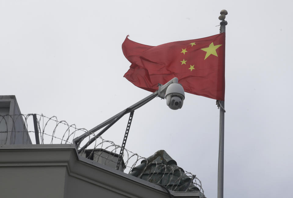 The flag of China flies behind a security camera over the Chinese Consulate in San Francisco, Thursday, July 23, 2020. The Chinese consulate in San Francisco is harboring a Chinese researcher who the FBI says lied about her military background. (AP Photo/Jeff Chiu)