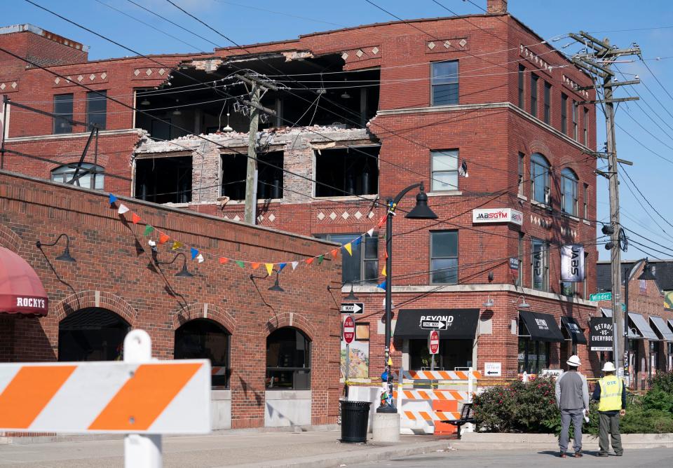 Two DTE workers look at a partially collapsed building in Eastern Market on Monday, Sept. 18, 2023.
