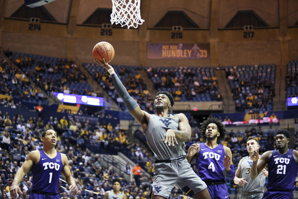 West Virginia forward Derek Culver (1) shoots as TCU guards Desmond Bane (1) and PJ Fuller (4) and TCU center Kevin Samuel (21) defend during the second half of an NCAA college basketball game Tuesday, Jan. 14, 2020, in Morgantown, W.Va. (AP Photo/Kathleen Batten)