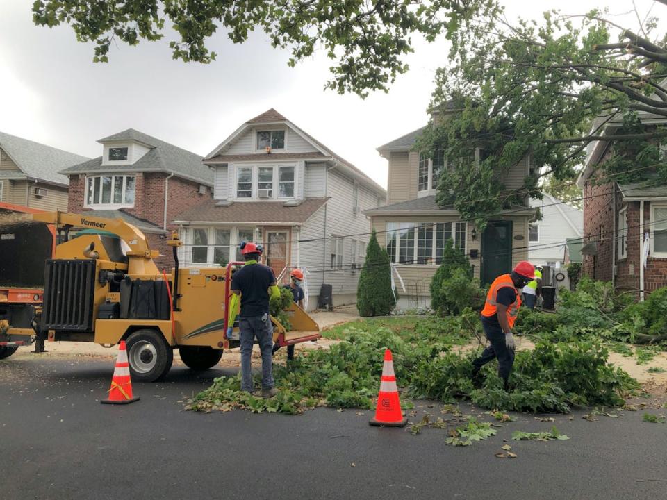 Tree crew chipping downed tree branches in the street