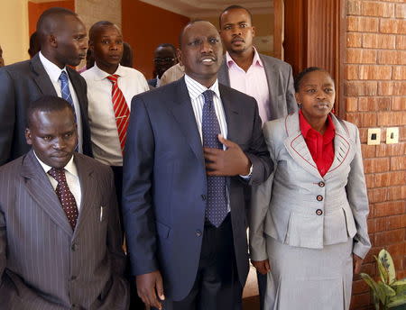 Former Kenyan cabinet minister William Ruto (C) stands next to his wife Rachel (R) and Kenyan radio presenter Joshua Arap Sang (L) in Ruto's house after hearing the news from the International Criminal Court in Nairobi in this January 23, 2012 file photo. REUTERS/Goran Tomasevic/Files