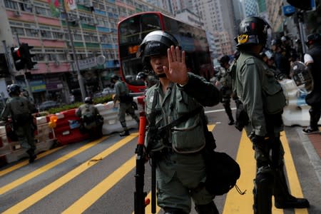 Riot police officers remove a barricade set up by anti-government protesters during a gathering in Tsuen Wan, near the site where police shot a protester with live ammunition on China's National Day in Hong Kong