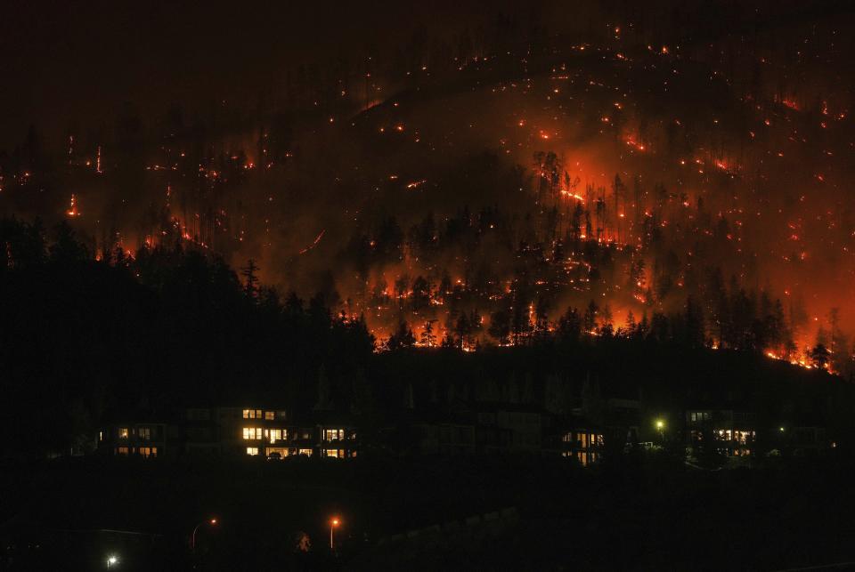 The McDougall Creek wildfire burns on the mountainside above houses in West Kelowna, British Columbia, on Aug. 18, 2023. (Darryl Dyck/The Canadian Press via AP)