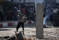 Demonstrators throw rocks at riot policemen during protests at the Cheikh Anta Diop University campus in Dakar, Senegal, against the arrest of opposition leader and former presidential candidate Ousmane Sonko, Thursday, March 4, 2021. (AP Photo/Leo Correa)