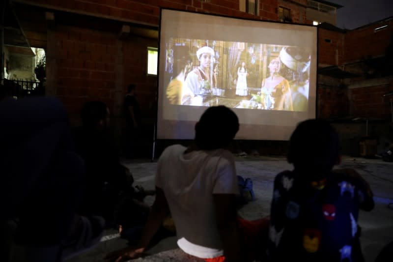 Children watch a movie projected on a giant screen for people to watch from their windows in the low-income neighborhood of Petare, amid the coronavirus disease (COVID-19) outbreak in Caracas