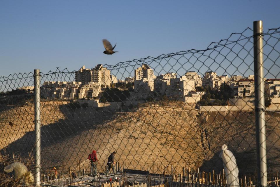 Palestinian laborers work at a construction site in a new housing project in the Israeli settlement of Maale Adumim, near Jerusalem, Tuesday, Feb. 7, 2017. A Palestinian Cabinet minister on Tuesday called on the international community to punish Israel for a contentious new law, just hours after the Israeli parliament adopted the bill to retroactively legalize thousands of West Bank settlement homes built unlawfully on private Palestinian land.(AP Photo/Oded Balilty)