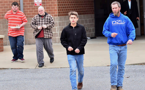 Family members escort their children out of Marshal North Middle School near Palma - Credit: AP