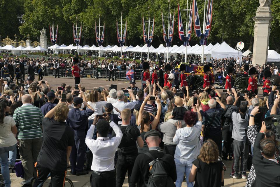 FILE - Media tents line the background as people take photos of the Royal family following the coffin of Queen Elizabeth II, during a procession from Buckingham Palace to Westminster Hall in London, Wednesday, Sept. 14, 2022. Plans by news organizations that have been in place for years — even decades — to cover the death of Queen Elizabeth II were triggered and tested when the event took place. London has been inundated with journalists, with more headed to the city for the funeral services on Monday. (AP Photo/Markus Schreiber, File)