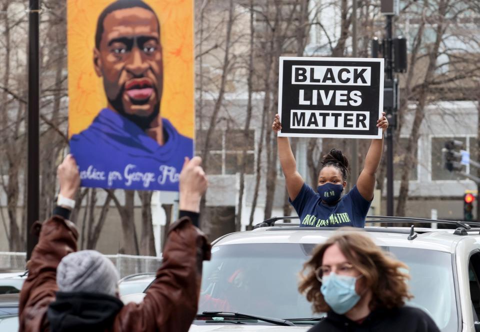 People hold signs on the street.