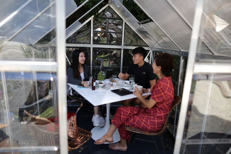 People eat lunch in a social distancing greenhouse dining pod amid the outbreak of the coronavirus disease (COVID-19) in Los Angeles