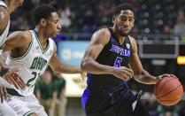 FILE - Buffalo guard CJ Massinburg drives on Ohio guard Antonio Cowart Jr. during the first half of an NCAA college basketball game, Tuesday, March 5, 2019, in Athens, Ohio. Buffalo won 82-79. College basketball is undergoing a shift, a new era ushered in by the transfer portal, NIL and conference realignment. Teams like Buffalo, Furman, Wofford and Florida Atlantic have been ranked for the first time in the past five years. (AP Photo/David Dermer, File)