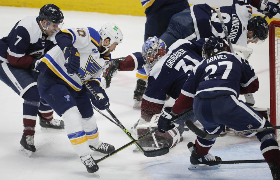 St. Louis Blues center Ryan O'Reilly (90) scores against Colorado Avalanche goaltender Philipp Grubauer (31) as Avalanche defensemen Devon Toews (7) and Ryan Graves (27) apply pressure during the first period of an NHL hockey game in Denver, Saturday, April 3, 2021. (AP Photo/Joe Mahoney)