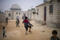 Syrian children play with a ball in a refugee camp for displaced people run by the Turkish Red Crescent in Sarmada district, north of Idlib city, Syria, Friday, Nov. 26, 2021. (AP Photo/Francisco Seco)