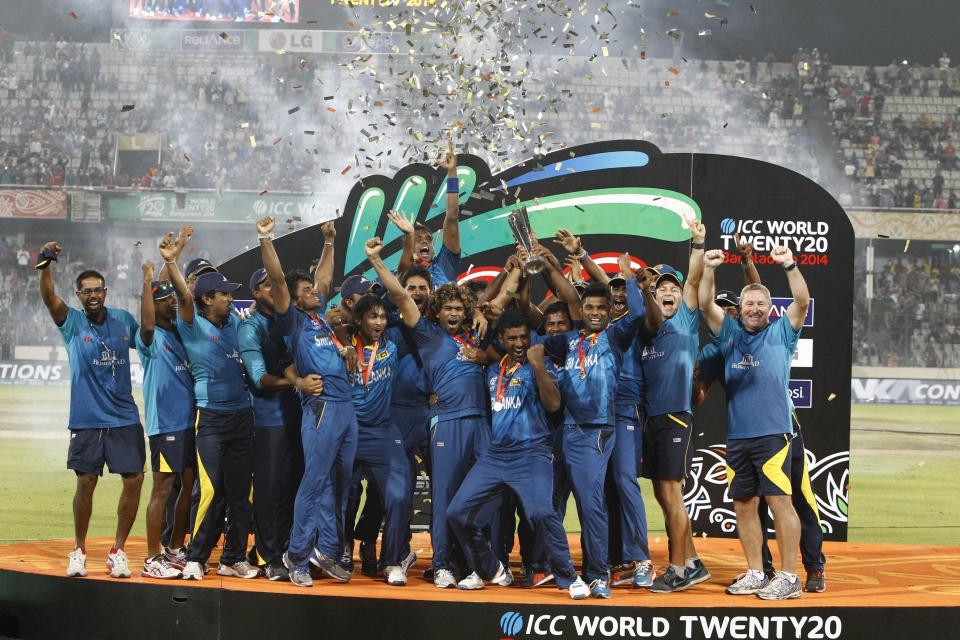 FILE - Sri Lanka's players and team officials pose for a group photo while celebrating with the trophy after winning the ICC Twenty20 Cricket World Cup in Dhaka, Bangladesh, Sunday, April 6, 2014. Sri Lanka won the title defeating India by six wickets. The ninth T20 World Cup starts on June 1. The Caribbean and the United States are sharing co-host duties. (AP Photo/A.M. Ahad, File)