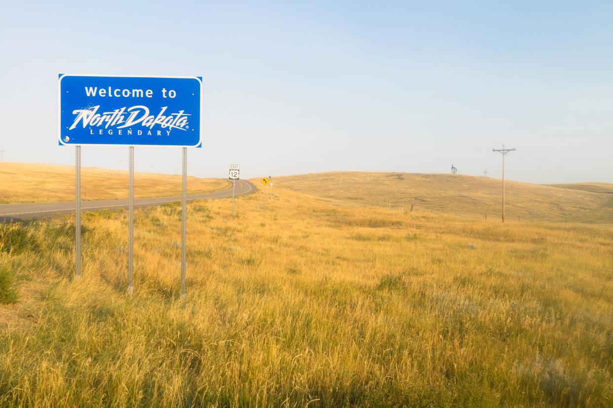 The scene is all blue and yellow at an entrance to North Dakota Road Sign