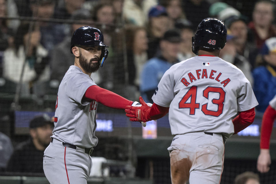 Boston Red Sox's Ceddanne Rafaela, right, is congratulated by Connor Wong after Rafaela scored against the Seattle Mariners during the fifth inning of a baseball game Saturday, March 30, 2024, in Seattle. (AP Photo/Stephen Brashear)
