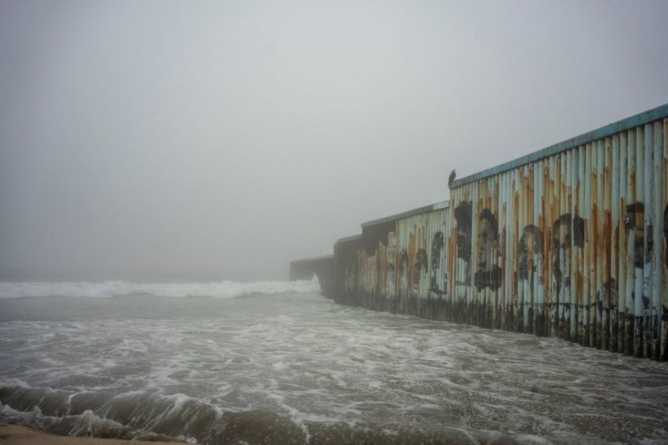 Waves crash against the US-Mexico border fence at Tijuana Beach ahead of Tropical Storm Hilary's landfall.