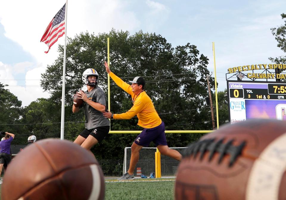 Calvary Assistant Coach Russell DeMasi pressures quarterback Jake Merklinger as he looks to make a pass during practice.