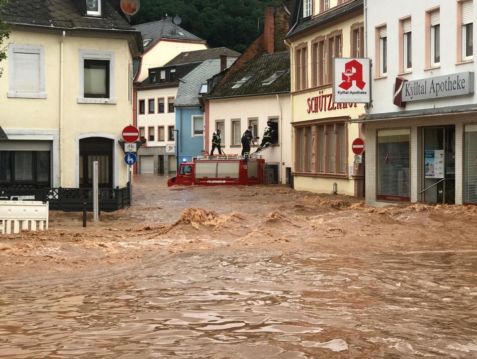 Fire fighters stand atop their vehicle as they climb into a house in the flooded village of Ehrang in Rhineland-Palatinate (Fire Brigades City of Trier/AFP/Getty)