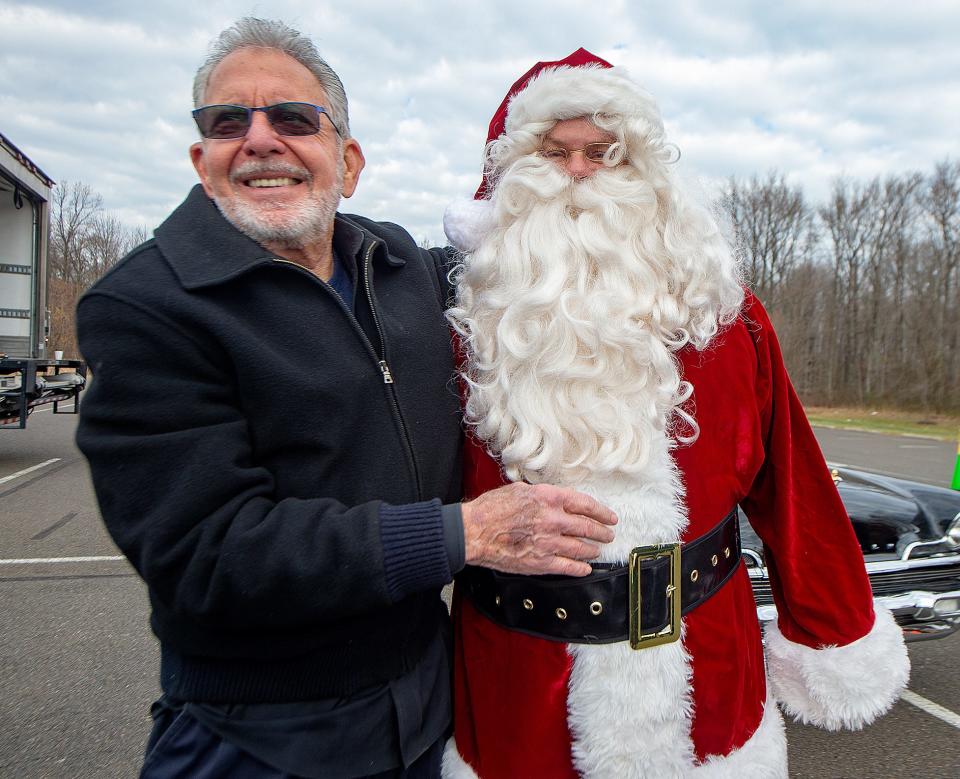 Ready to start the cash giveaway outside the Lower Bucks County Community College, in Bristol are philanthropist Gene Epstein, left, of Buckingham, and Santa, on Friday, Dec. 10, 2021. Santa helper Bill Saul, of Croydon, helped with the giveaway.