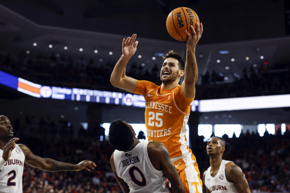 Tennessee guard Santiago Vescovi (25) is fouled as he puts up a shot over Auburn guard K.D. Johnson (0) during the first half of an NCAA college basketball game Saturday, March 4, 2023, in Auburn, Ala. (AP Photo/Butch Dill)
