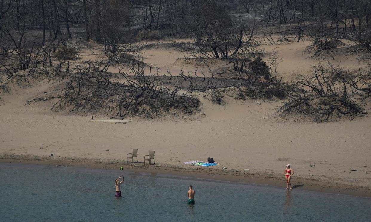 <span>A few holidaymakers return to the sea near Gennadi village, Rhodes, in July 2023 after the devastating wildfires.</span><span>Photograph: Petros Giannakouris/AP</span>