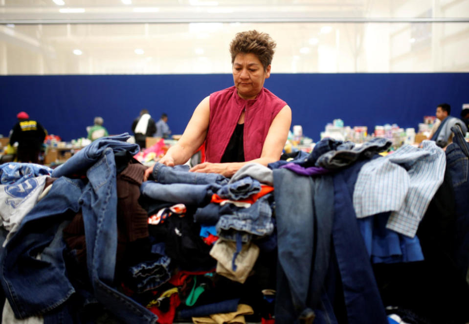 An evacuee goes through donated clothing