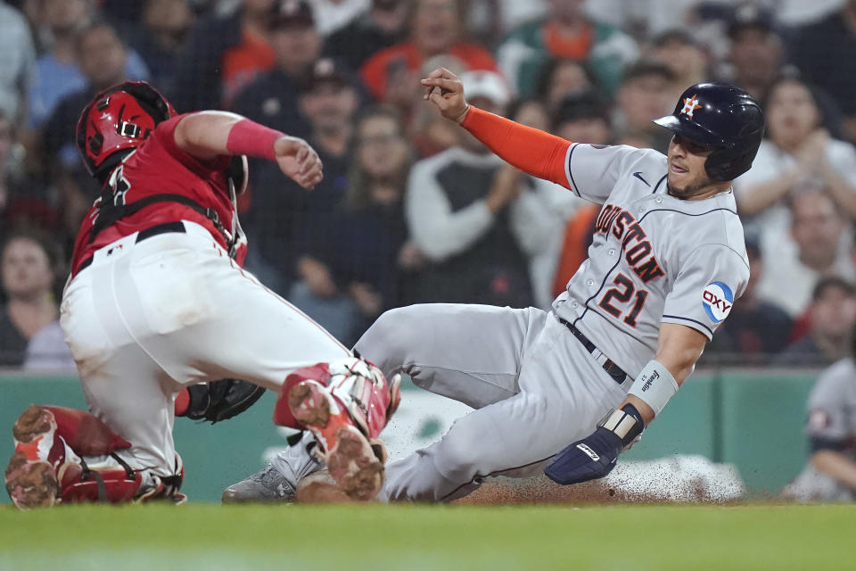 Houston Astros' Yainer Diaz (21) scores on a two-run double by Mauricio Dubon as Boston Red Sox catcher Reese McGuire, left, is unable to tag him during the sixth inning of a baseball game Tuesday, Aug. 29, 2023, in Boston. (AP Photo/Steven Senne)