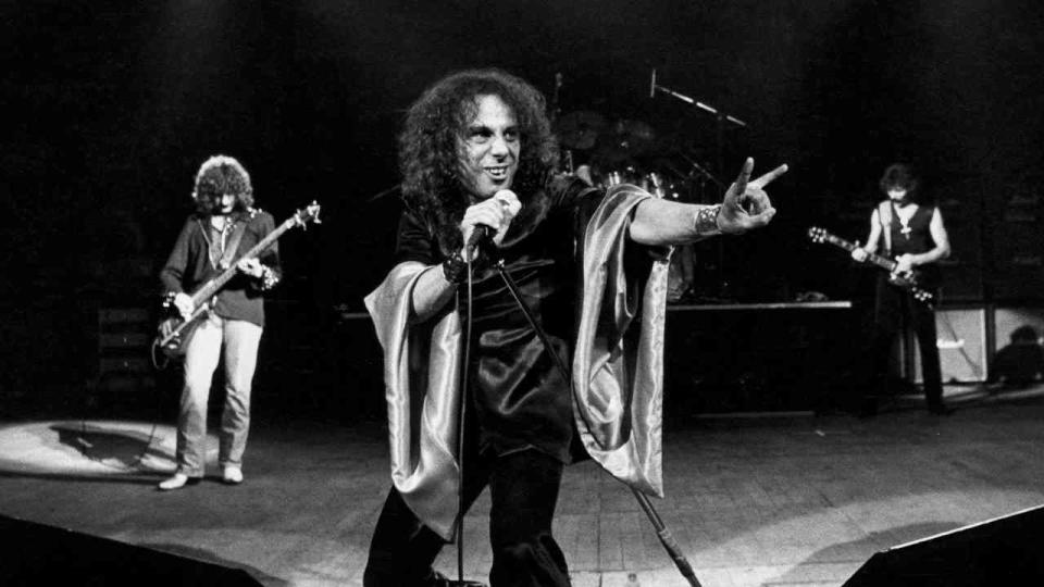 Ronnie James Dio making devil horns onstage with Black Sabbath