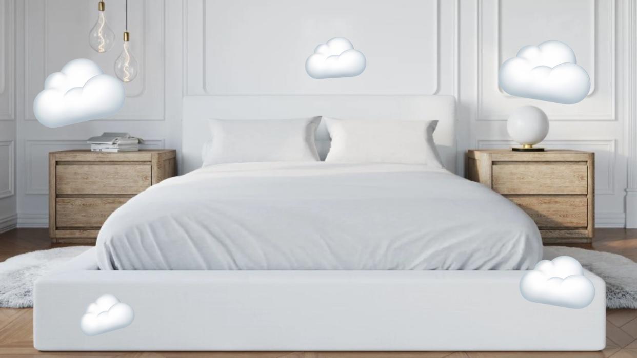  A white upholstered bed with cloud emojis around it. 