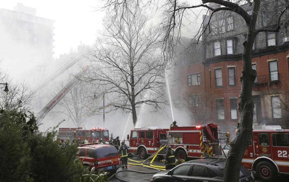 Fighters battle a multi-alarm fire at a four-story brownstone in the Back Bay neighborhood near the Charles River, Wednesday, March 26, 2014, in Boston. A Boston city councilor said two firefighters have died in a fire that ripped through a brownstone. (AP Photo/Steven Senne)